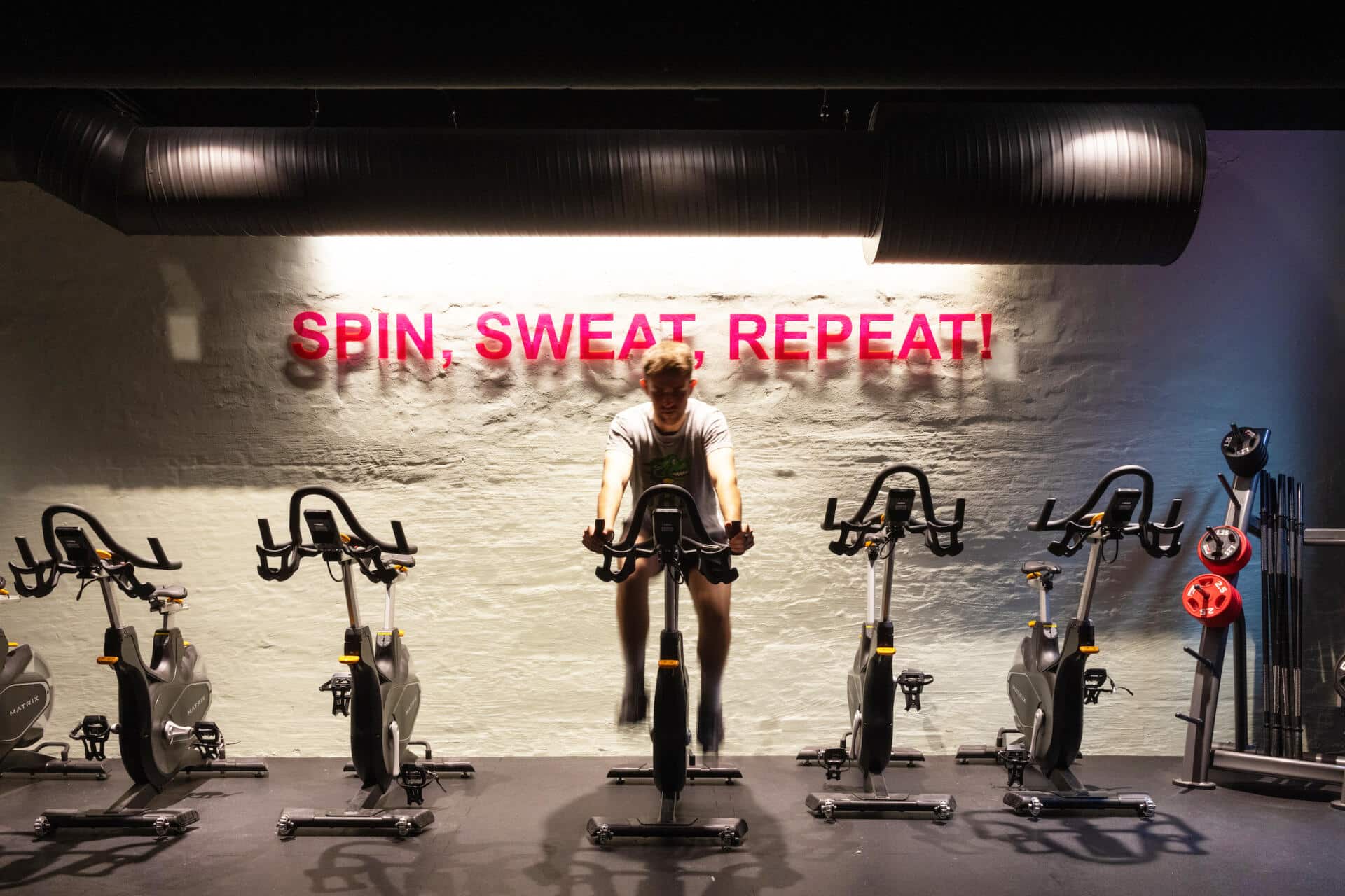 a student rides an exercise bike in the 24h Gym at Basecamp Copenhagen dormitory