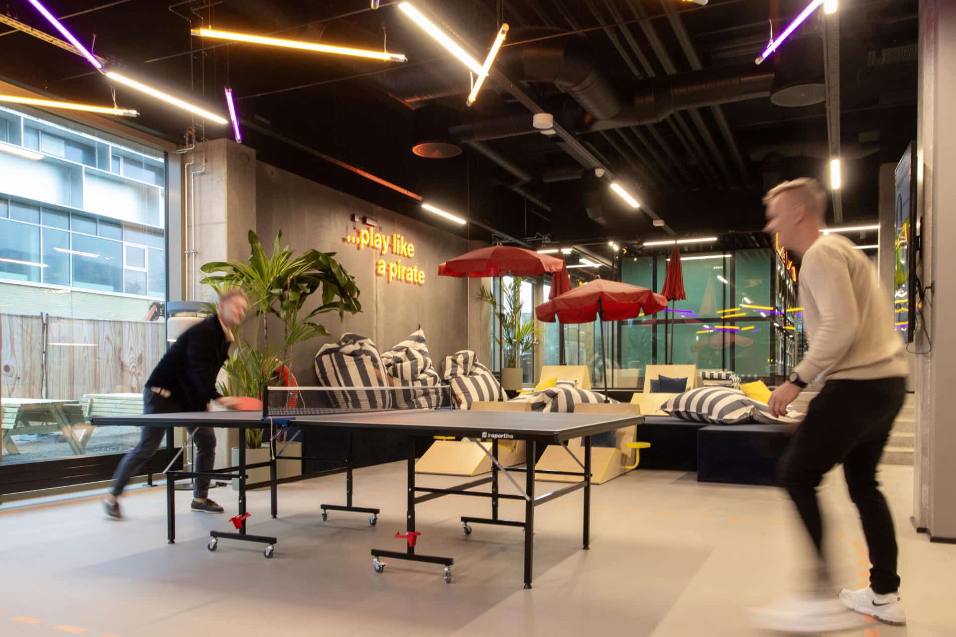 Two students playing on the table tennis table in the game zone at Basecamp Aarhus student accommodation