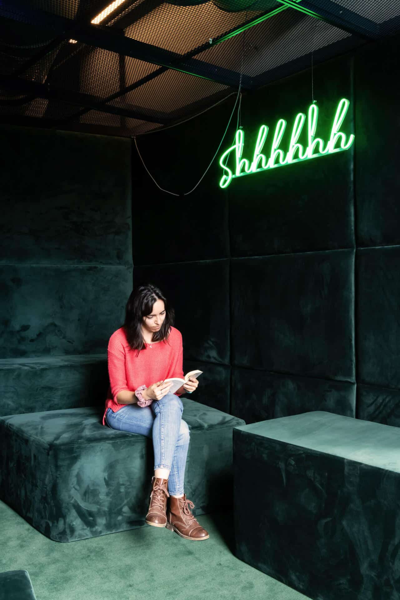 A girl reads a book in a lounge area at Basecamp Lyngby