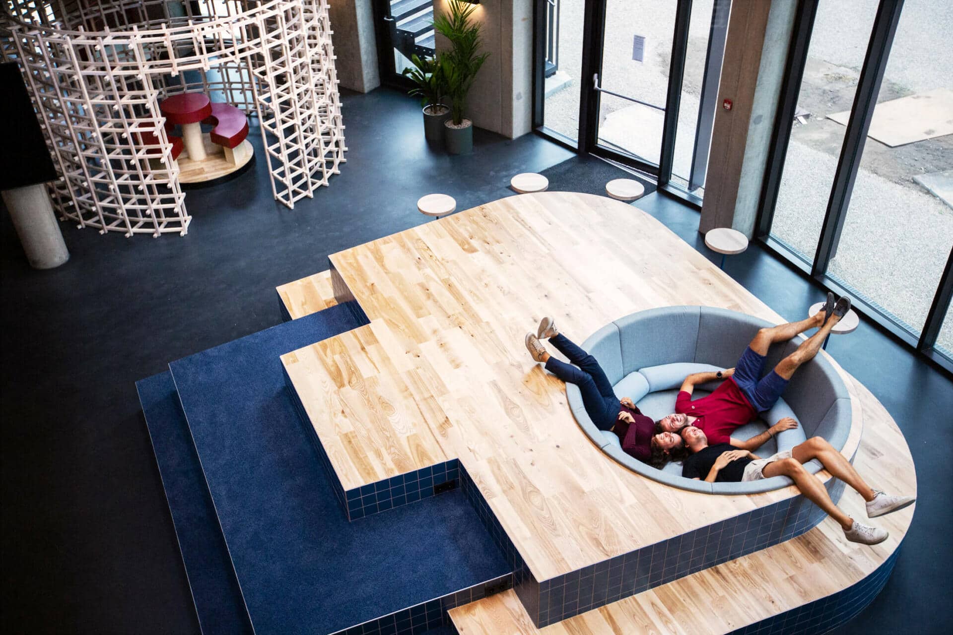 Three students laugh while sitting in a modern sofa at Basecamp lyngby student dormitory