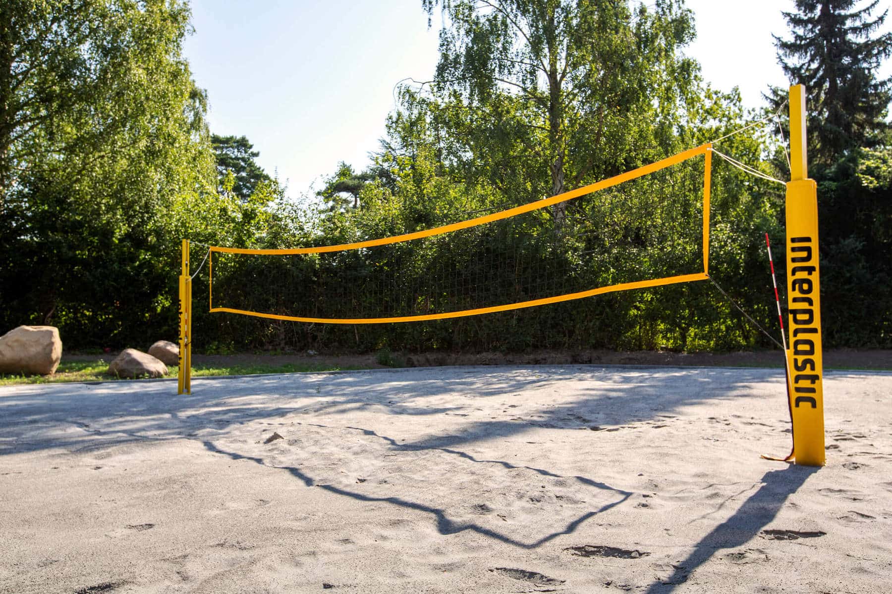 Volleyball court with a yellow net in the outdoors area of Basecamp Lyngby student accommodation