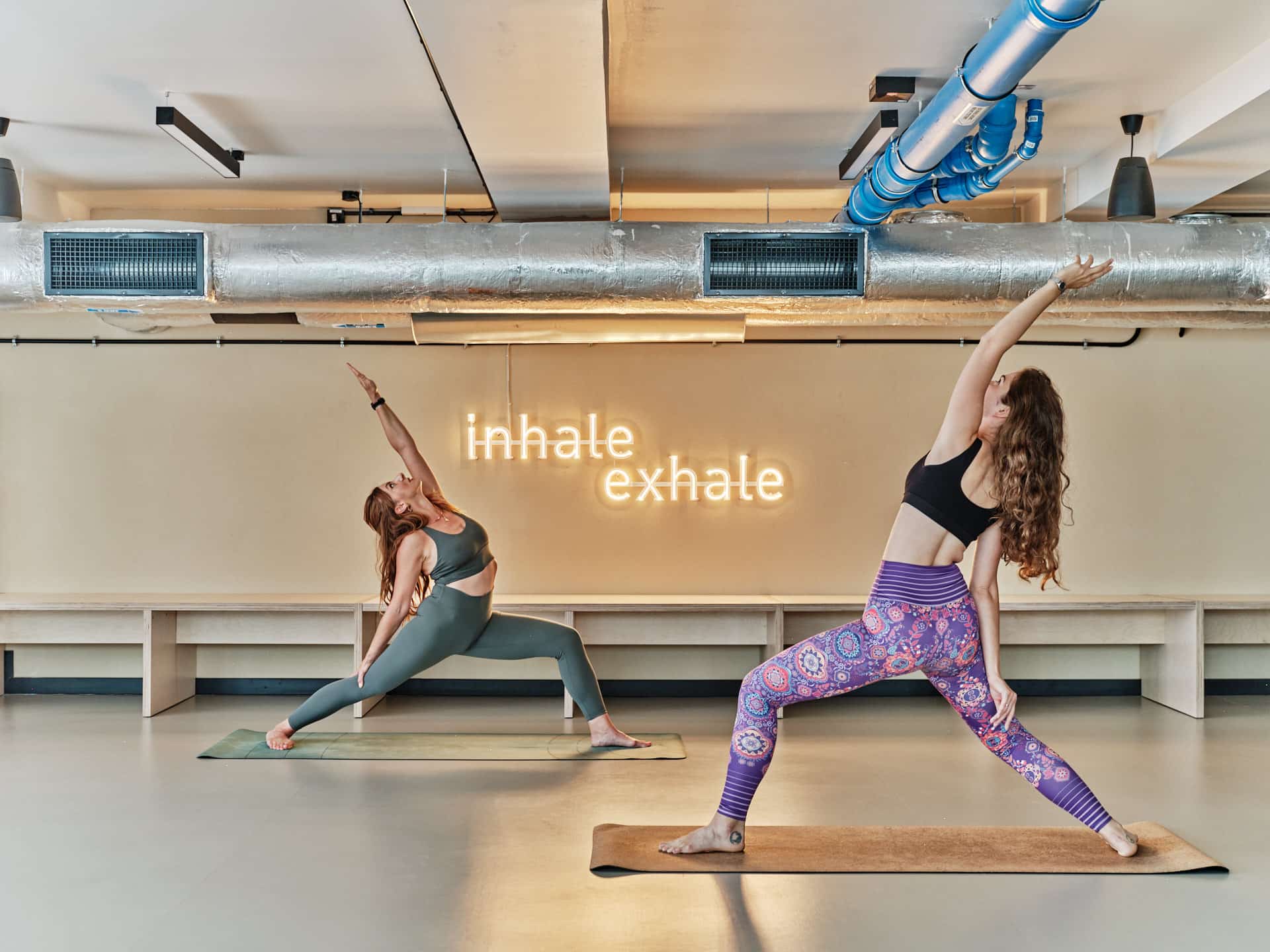 Two female students do yoga in the Fitness room at Wroclaw Basecamp student accommodation