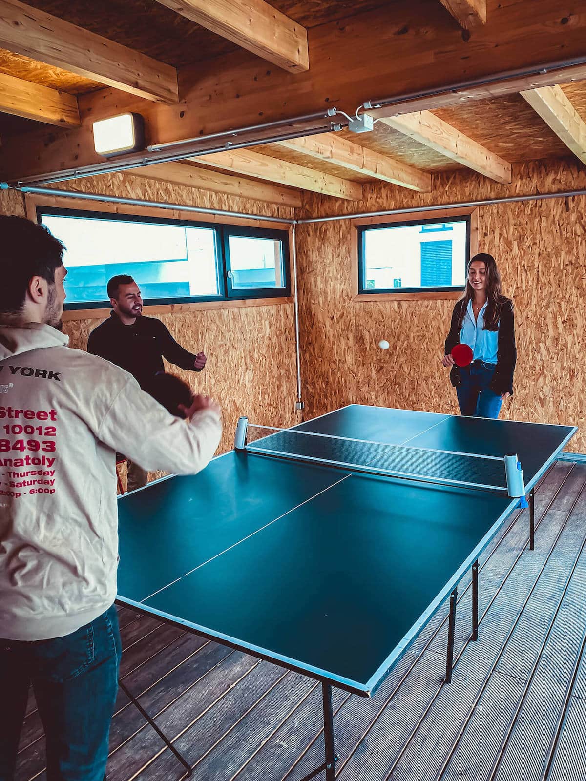 three students play pingpong at Basecamp Leipzig student accommodation