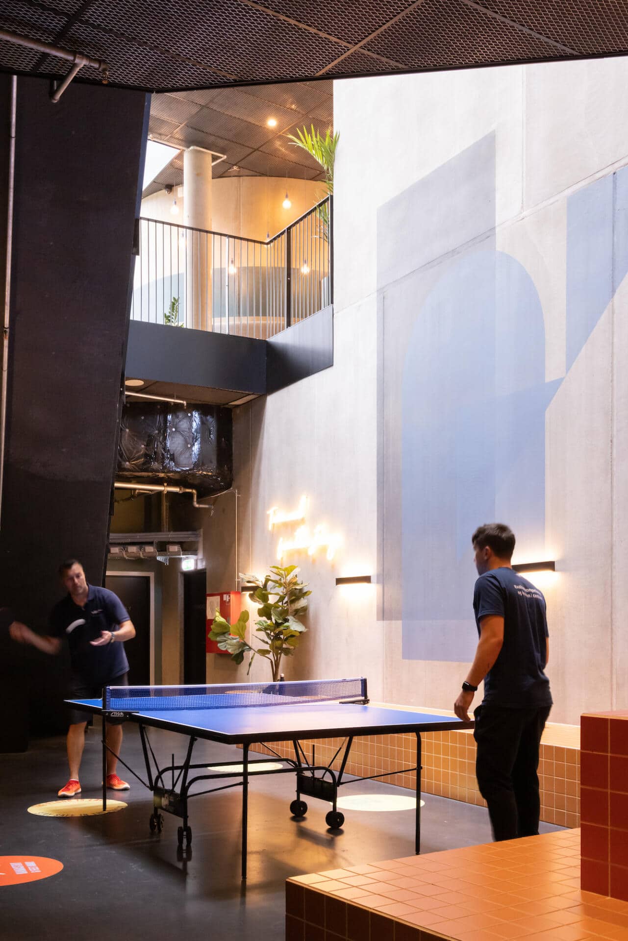 students play pingpong in a common area of Basecamp Lyngby student accommodation