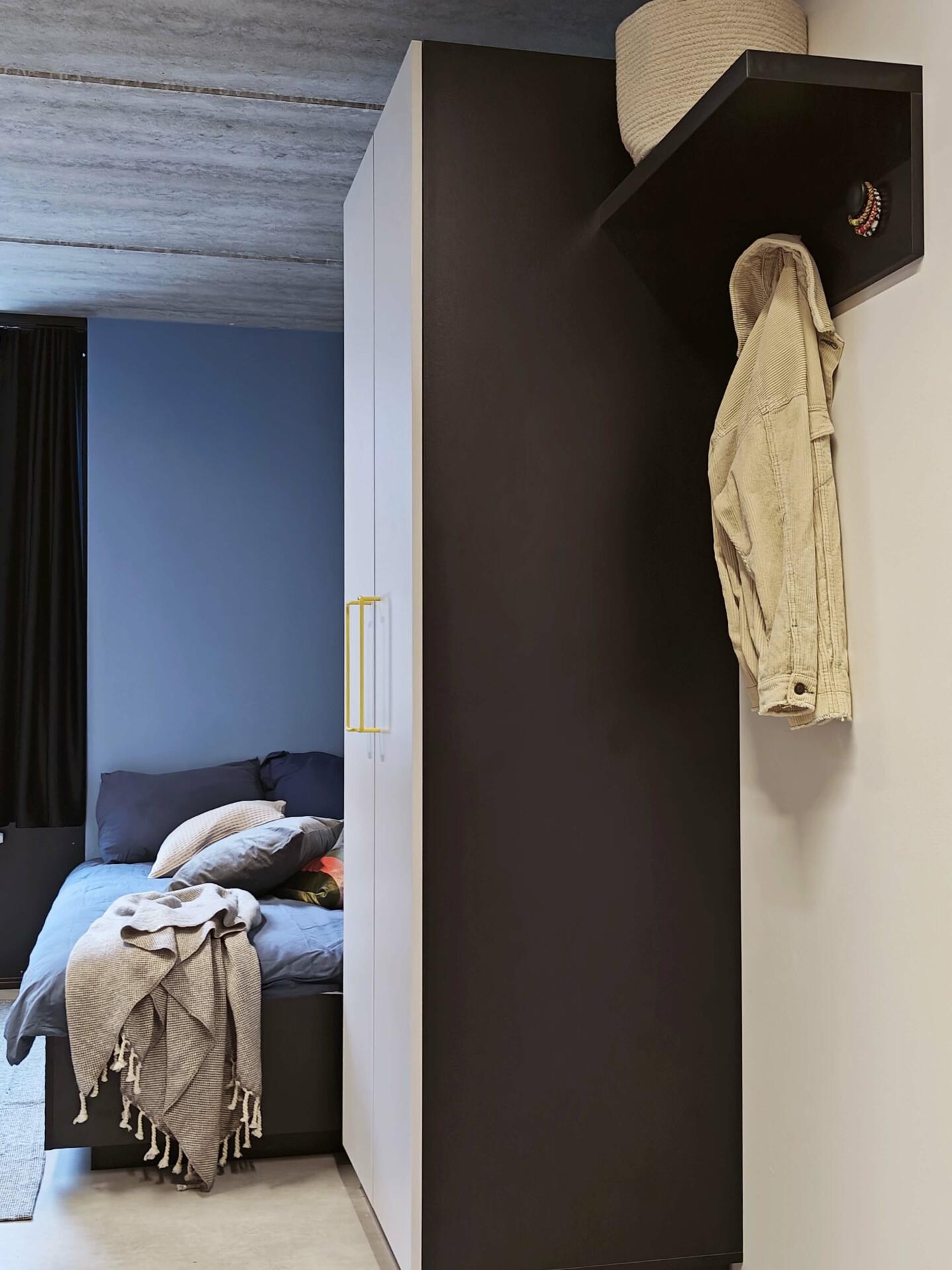 Bed and wardrobe in a single room at Basecamp Malmö student housing