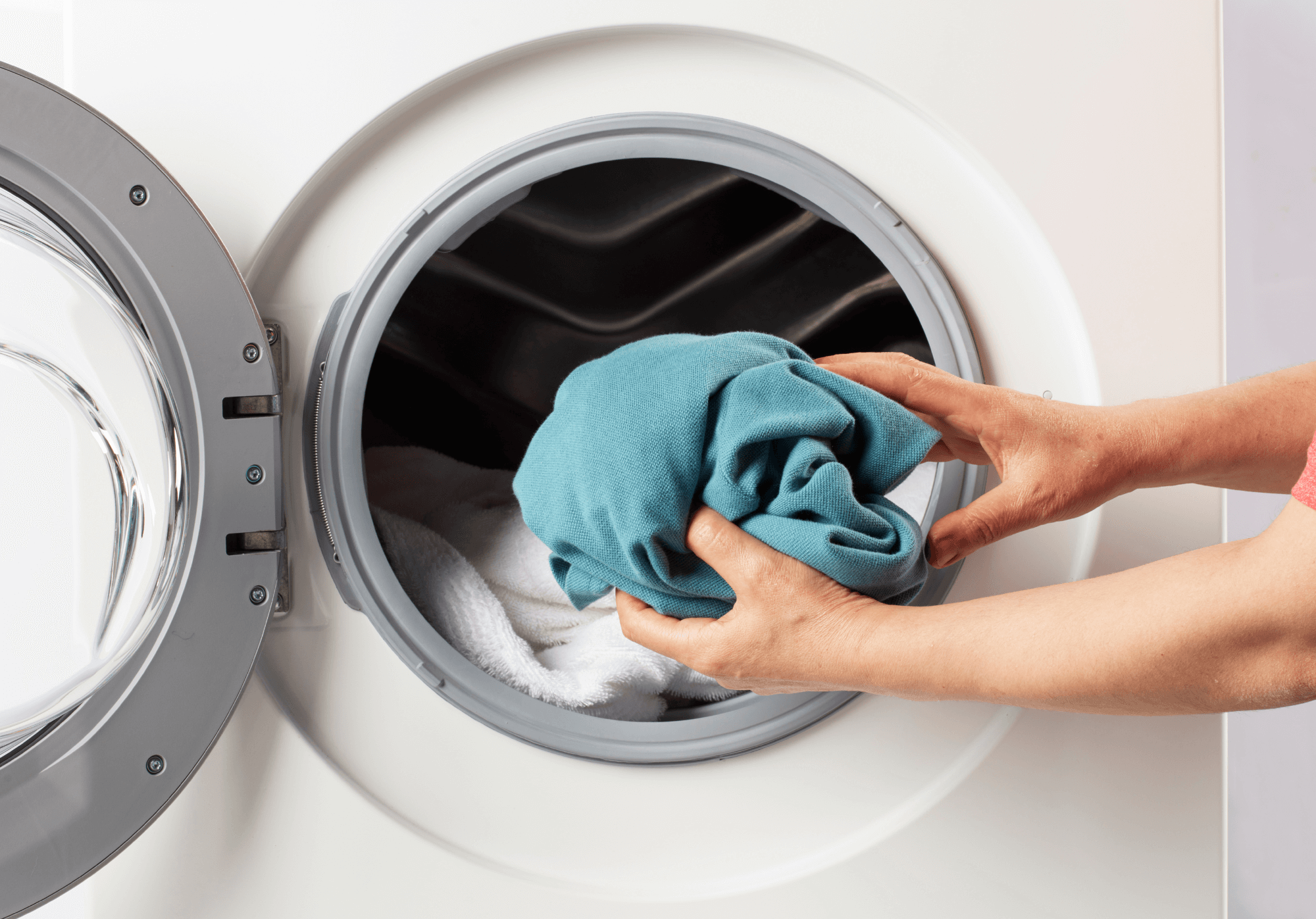 A student uses a laundry machine at Basecamp Copenhagen student accommodation