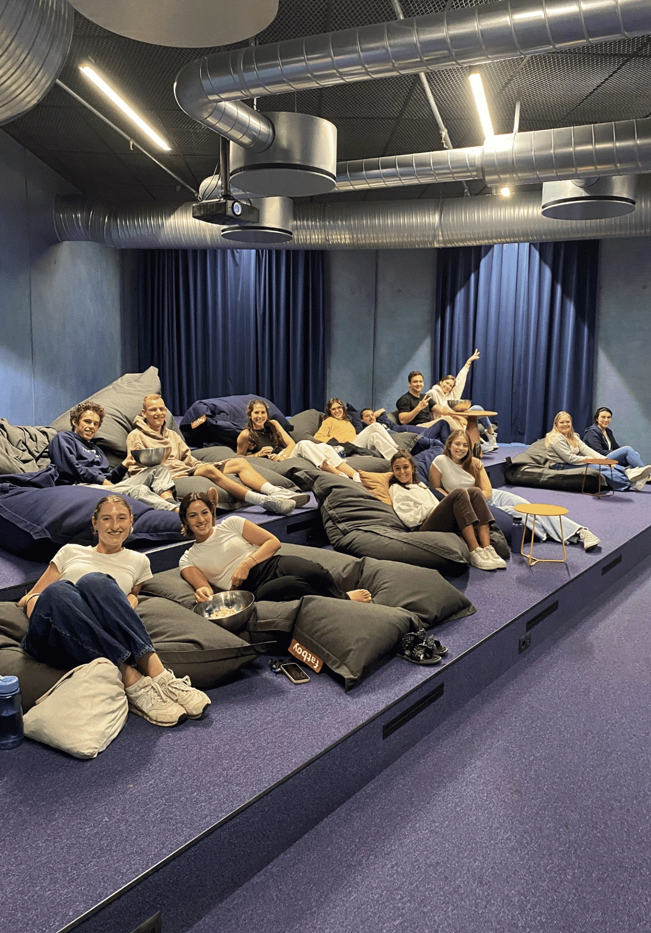 A group of female students watching a movie at Basecamp Lyngby student accommodation's cinema room