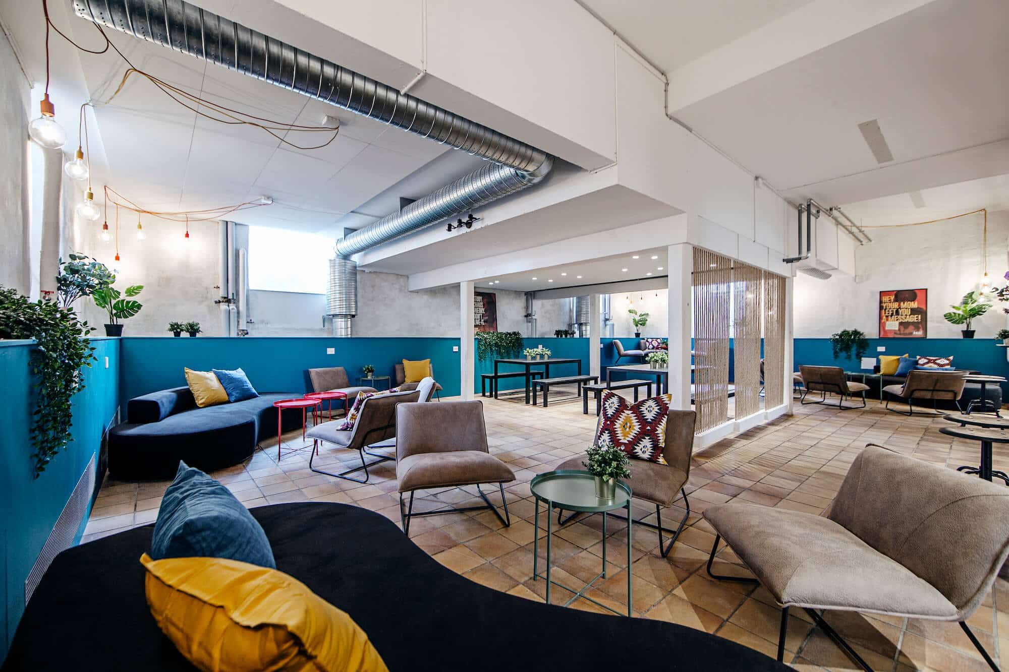 Common space with colourful sofas and tables at Basecamp Copenhagen student housing