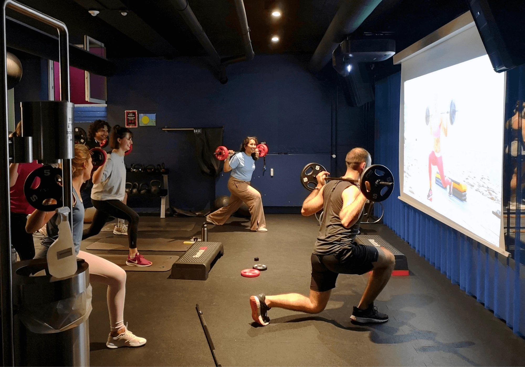 Students exercise with weights in the state of the art gym at Basecamp Copenhagen South Campus Student housing